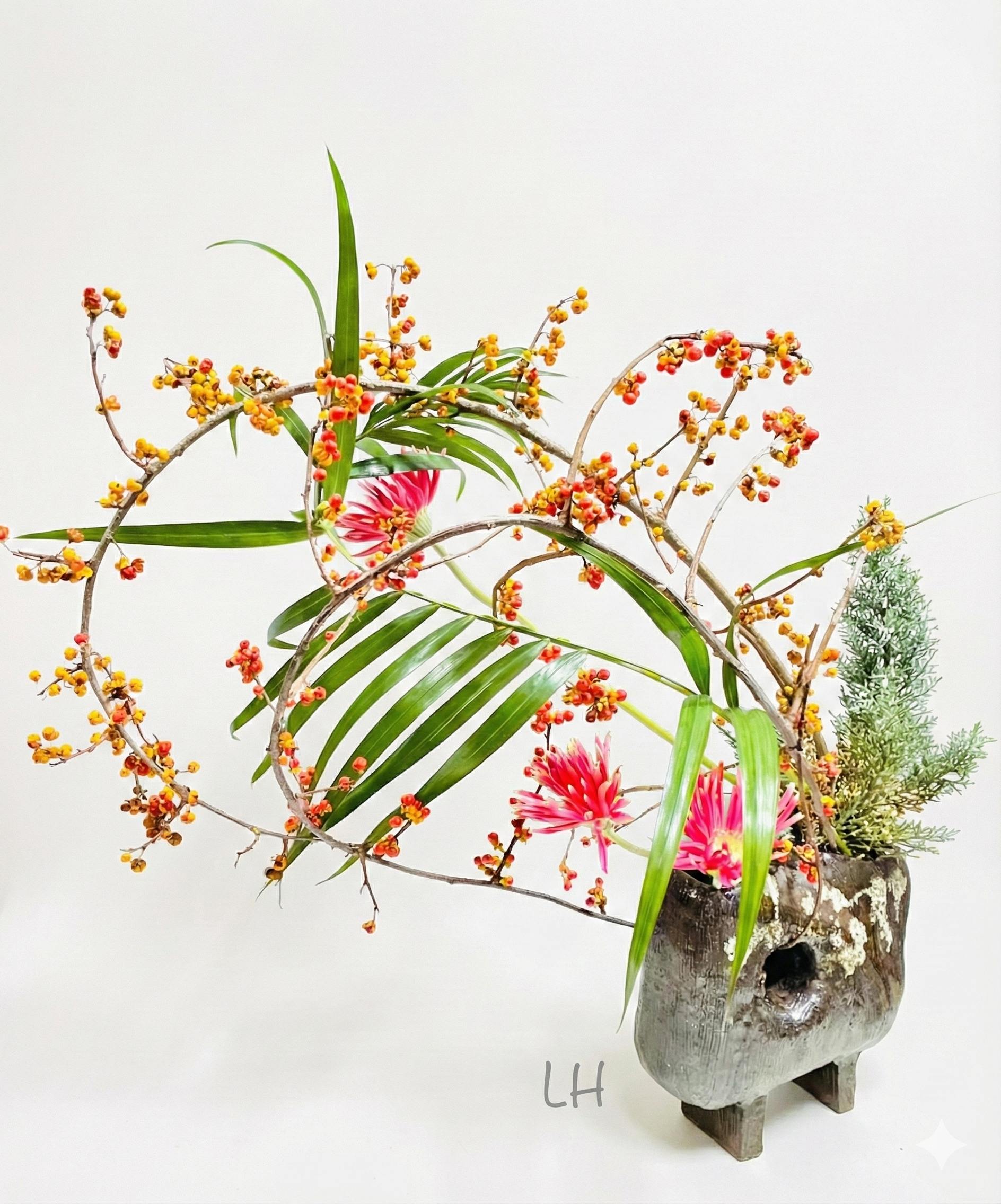 Beautiful ikebana arrangement with pink flowers and pottery vase